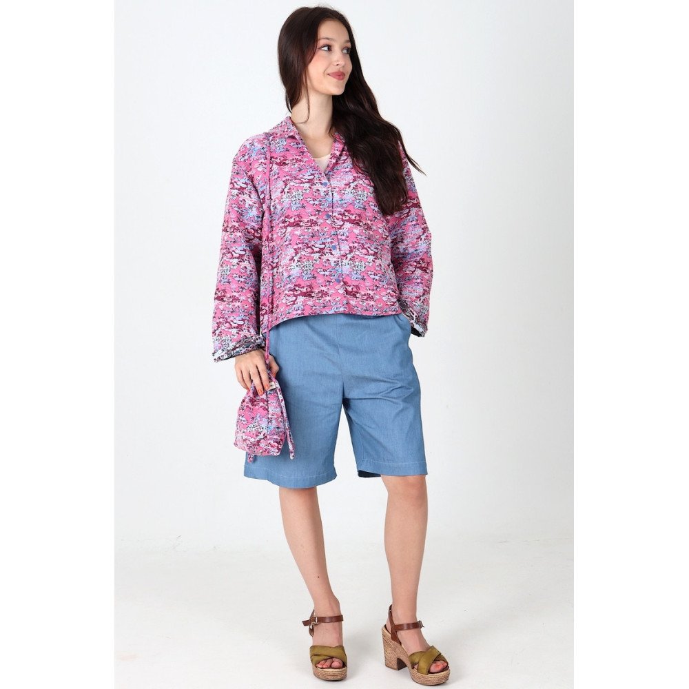 Veste Gabrielle en jacquard rose portée avec le bermuda Diane en chambray bleu.