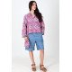 Veste Gabrielle en jacquard rose portée avec le bermuda Diane en chambray bleu.
