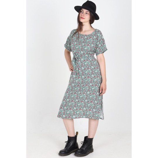 Robe fleurie verte Loretta portée de face, ceinturée à la taille.
