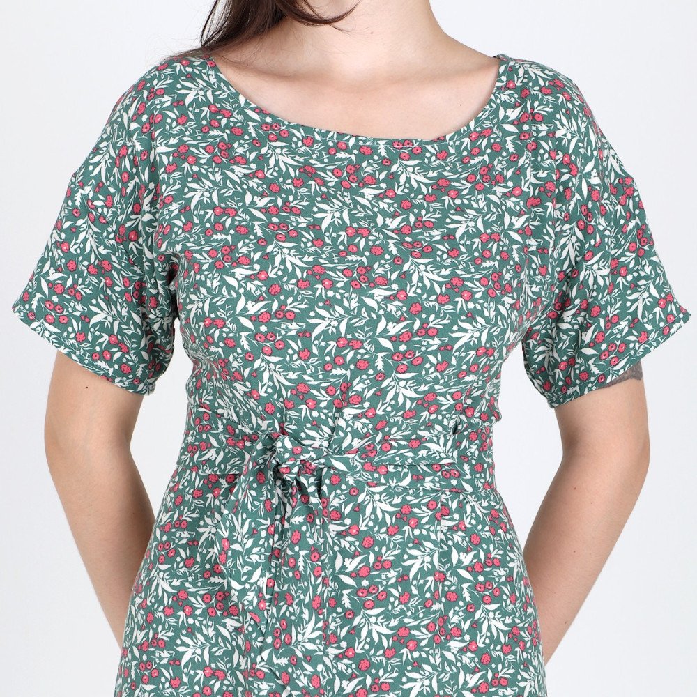 Détail de l’encolure ronde, du nœud et du motif floral de la robe Loretta.